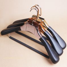 three pairs of black and gold scissors sitting on top of each other in front of a beige background