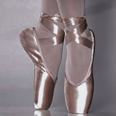 the feet of a ballerina in shiny silver shoes