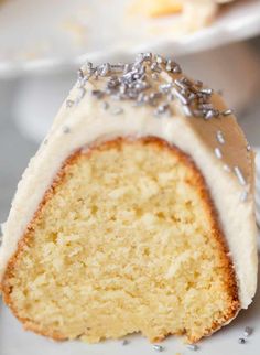 a slice of cake with white frosting and sprinkles