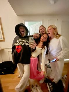 four women taking a selfie in the living room with their cell phone and shoes