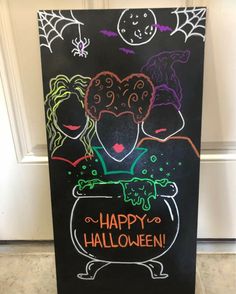 a chalkboard sign with halloween images on it that says happy halloween and two witches in a caulder