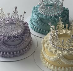 three different colored cakes with tiaras on them