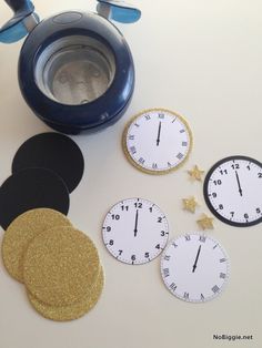 there are clocks and coasters next to a teapot on the table with gold stars