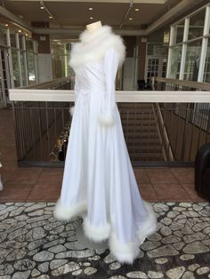 a white wedding dress on display in front of a window