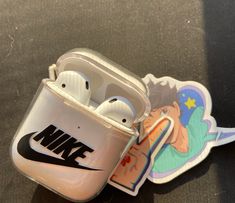 an apple airpods case sitting on top of a table next to a sticker