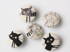 four black and white buttons with cats on them