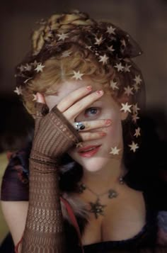 a woman with stars on her head covering her eyes