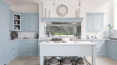 a kitchen with light blue cabinets and white counter tops, along with a large clock on the wall