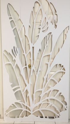 a white door with cut out leaves on it