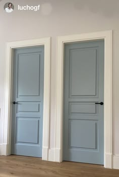 three blue doors in an empty room with hardwood floors and white walls, one is painted light blue