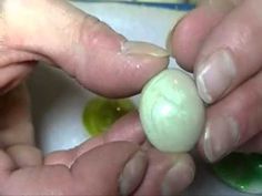 someone is peeling an egg with their fingers