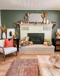 a woman sitting on a chair in front of a fireplace with fall decorations around her