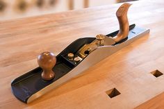 a wooden table topped with a pair of scissors and a stapler on top of it