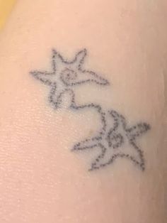 a small tattoo on the back of a woman's arm with two stars in it