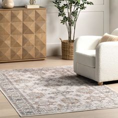 a living room with a couch, chair and rug on the floor in front of a wooden cabinet