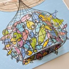 a card with an image of colorful fish in a cage on top of blue paper