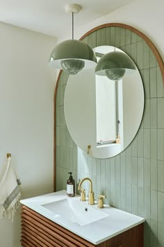 A curved wall area is filled with muted green tiles and a wooden frame, as a matching green light fixture is in the spotlight. Retro Powder Room, Zia Tile, Deco Studio, Creative Bathroom, Big Bathroom, Downstairs Bathroom, Bathroom Backsplash, Bathroom Inspiration Decor