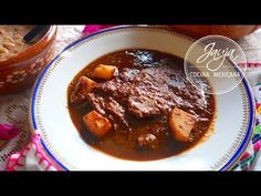 a white bowl filled with stew and potatoes