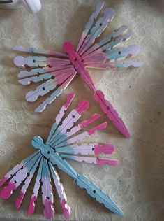 several pink and blue toothpicks are on a white lace tablecloth with a cup in the background