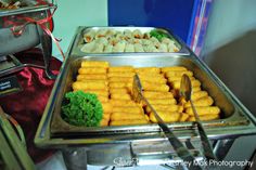 two trays filled with food sitting on top of a table next to each other