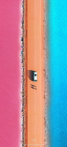 an aerial view of a beach with a car parked on the sand next to it