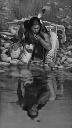 a native american woman kneeling in the water