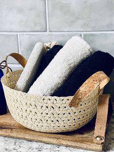 three towels in a basket on top of a cutting board