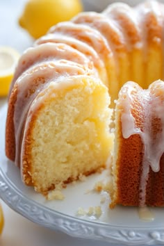 a lemon bunt cake on a plate with one slice cut out and ready to be eaten