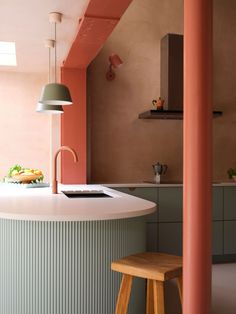 an island in the middle of a kitchen with stools next to it and a lamp hanging from the ceiling