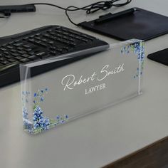 a clear acrylic business card holder with blue flowers