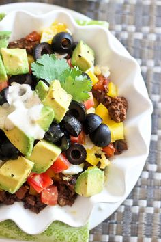 a white bowl filled with taco salad on top of a table