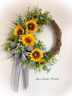 a wreath with sunflowers and greenery hanging on the wall