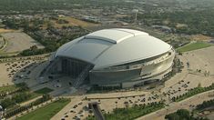 an aerial view of a stadium with cars parked in the parking lot and around it