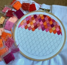 an embroidery project with different colored threads on the table