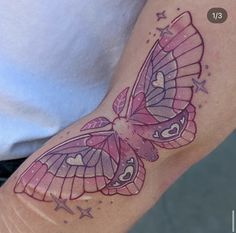 a woman's arm with a pink butterfly tattoo on the left side of her arm