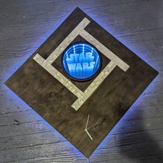 a star wars clock is shown on a wooden surface with blue light coming from it