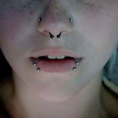 a woman with piercings on her nose looking at the camera