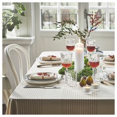 a table set with plates, glasses and candles