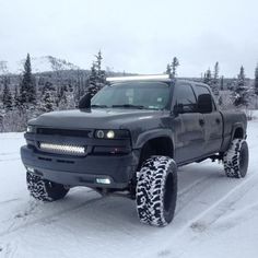 a black truck is driving through the snow