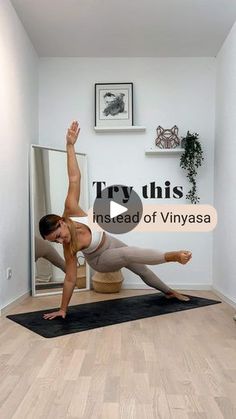 a woman doing yoga on a mat in the middle of a room with a mirror behind her