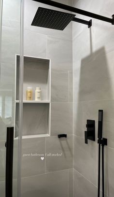 the shower head is mounted on the wall next to the shelf in the shower stall