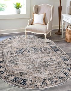 a large round rug with an ornate design on the floor in front of a chair