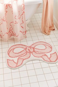 a bathroom with a pink bow rug on the floor