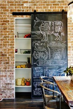 a chalkboard is in the middle of a room with an open door that leads to a kitchen