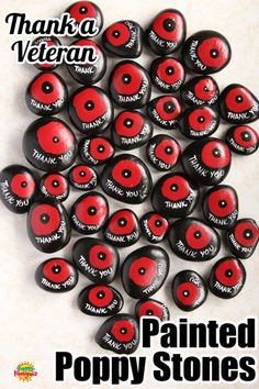 there are many red and black buttons on the table with words painted on them that say, painted poppy stones