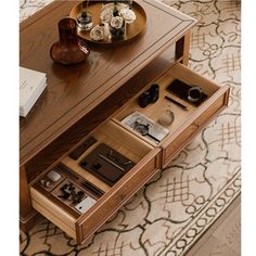 a coffee table with drawers on the bottom and an open drawer underneath it that holds various items