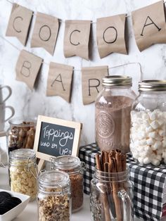 a table topped with jars filled with different types of candy and marshmallows