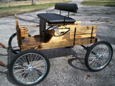 an old fashioned wooden car is parked on the gravel