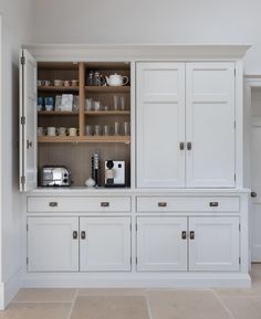 a kitchen with white cabinets and counter tops