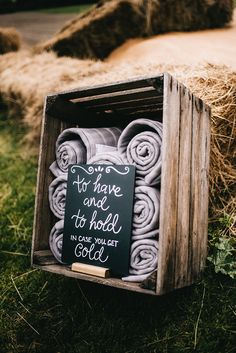 a wooden box filled with towels and a chalkboard sign that says you have one to hold in your pocket